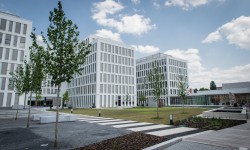 Exterior view of AirPlus's headquarters in Germany, modern building in a green setting.