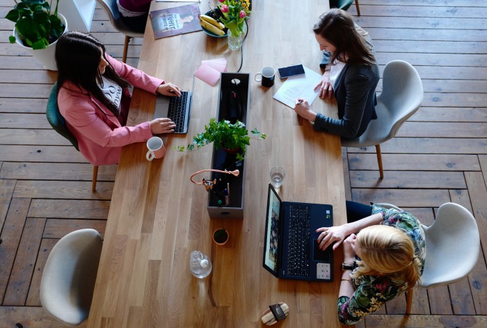 Top view of three women working at a large table.