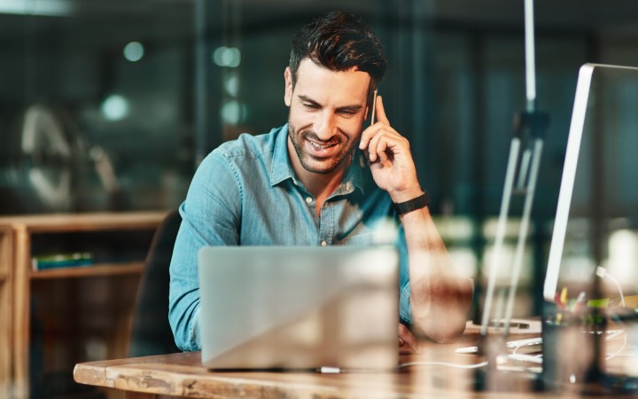 A man with a laptop at a desk, utilizing AirPlus payment solutions for the procurement process.