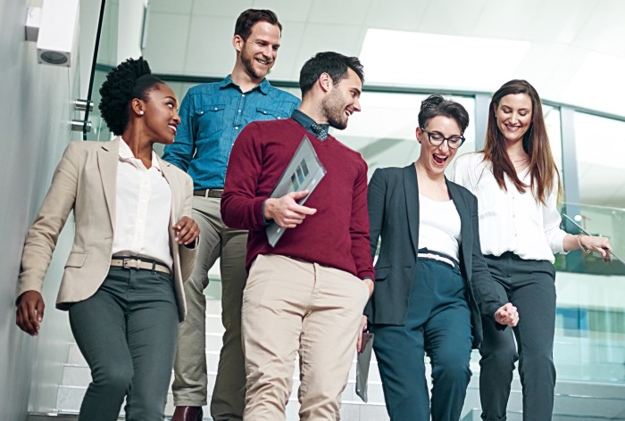 Colleagues walk down an office staircase together. The image symbolizes the open and collaborative company culture as well as AirPlus' commitment to a supportive work environment.