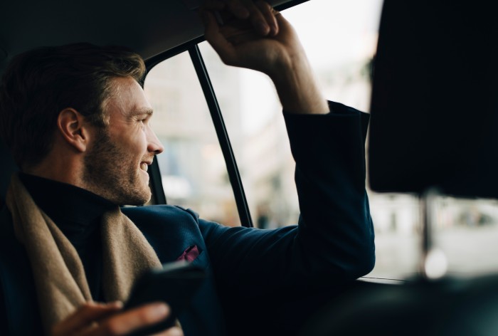 A man sits in a company car, symbolizing the benefits of being an AirPlus employee.