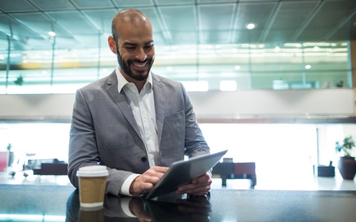 A businessman in a suit smiles and looks downward.